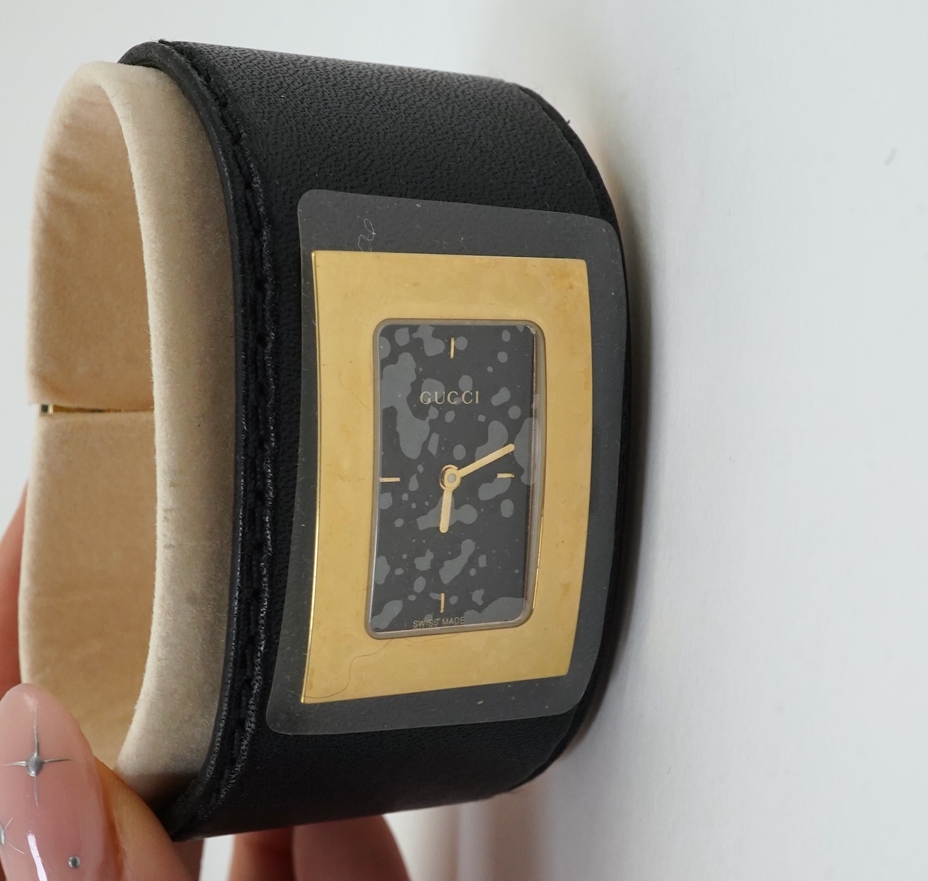 A lady's Gucci watch with wide leather strap, with box and papers.